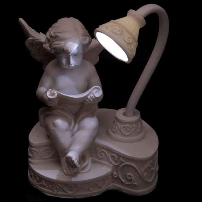 Lampe Ange chrubin avec livre sous une lampe